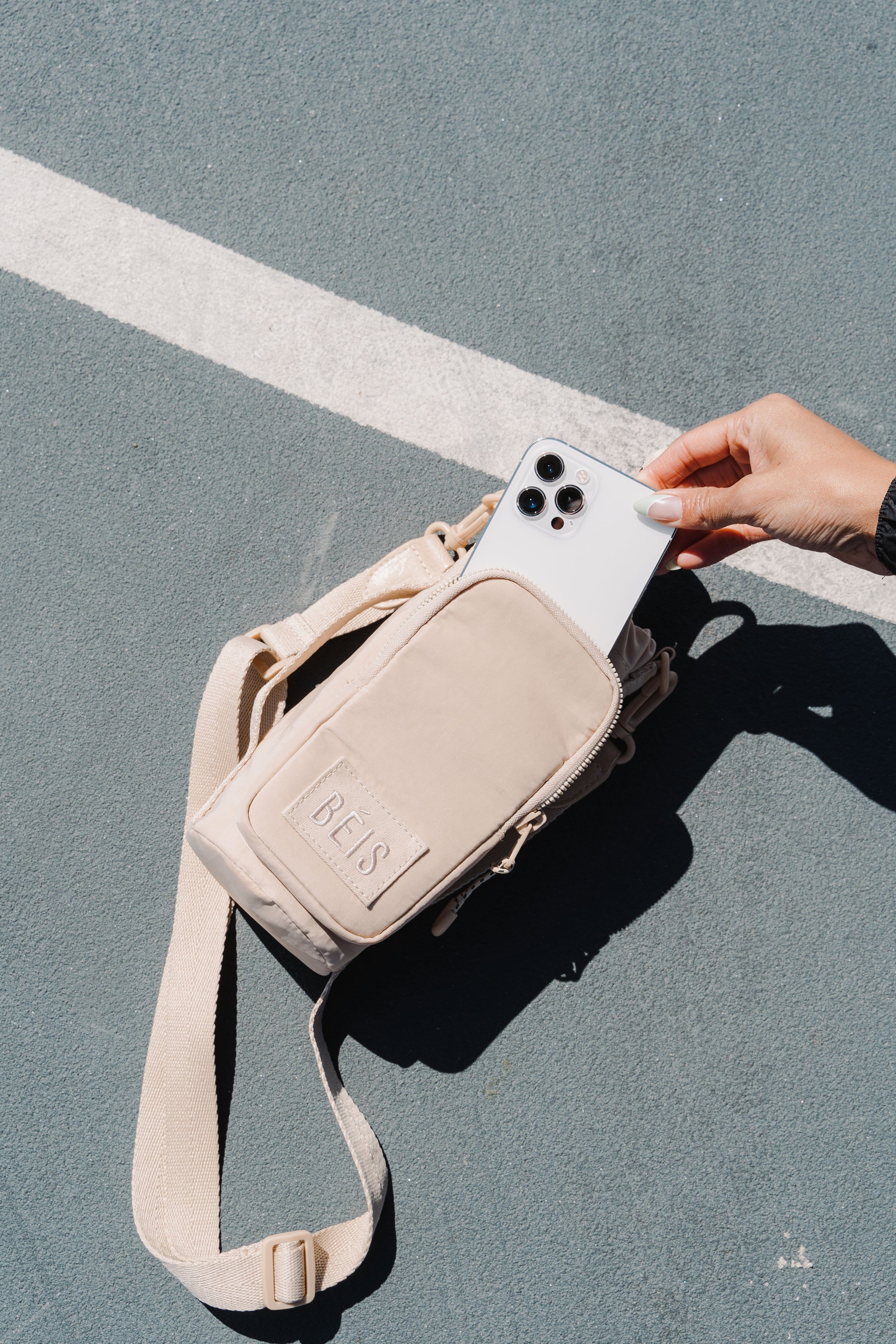 Water Bottle Sling Beige Front Phone Pocket on Court
